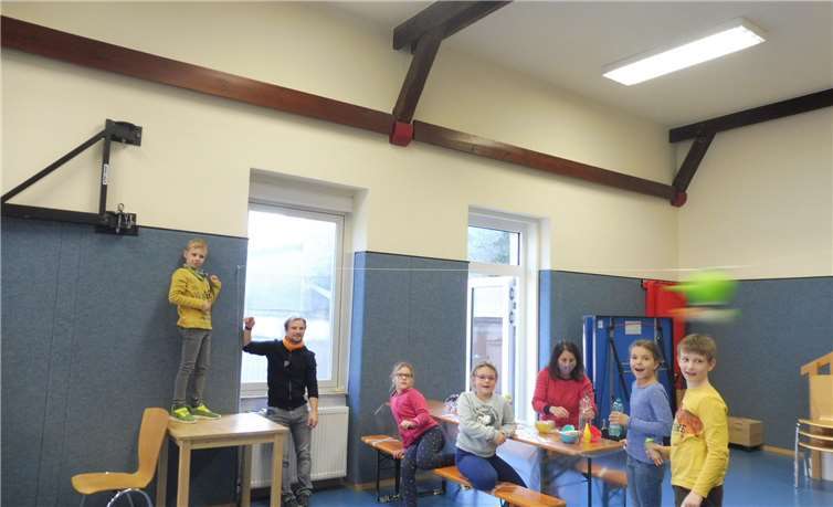 Die Kinder schießen ihre durch Luft angetriebene Rakete durch die Halle.