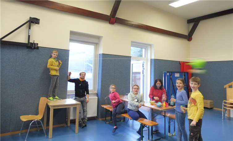 Die Kinder schießen ihre durch Luft angetriebene Rakete durch die Halle.