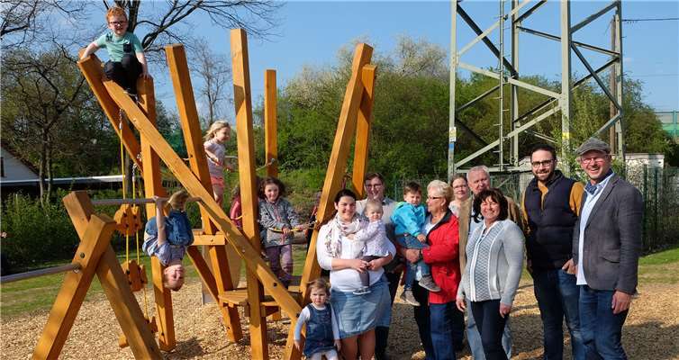 Die Kinder und ihre Eltern, Ortsbeiratsmitglieder und Nico Siebke (Bauamt Stadt Neuwied) und Harald Schwer (Amt für Jugend und Soziales) freuen sich gemeinsam über das neue Multifunktionsspielgerät.