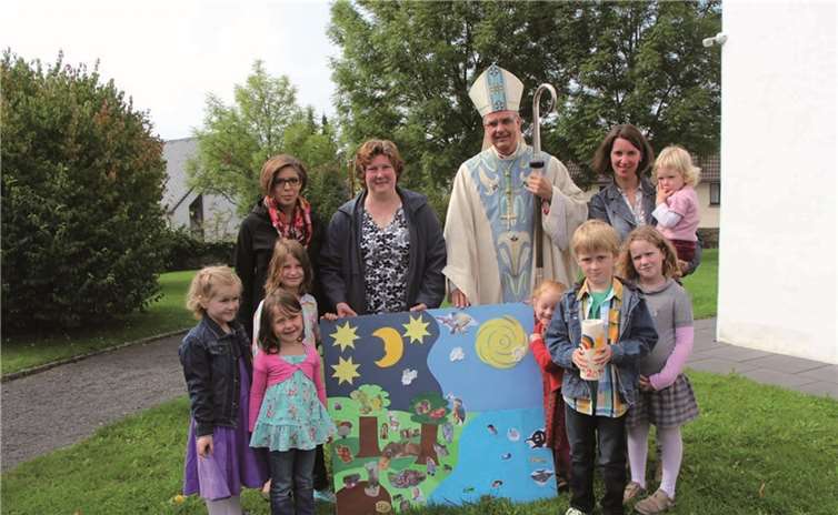 Die Kinder zeigen Weihbischof Peters, was sie in der Kinderkirche gestaltet haben. privat