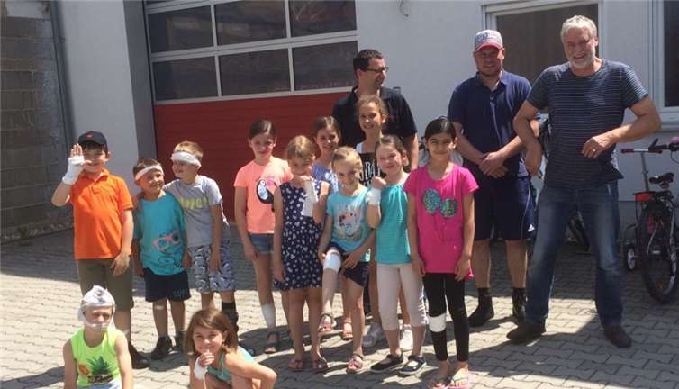 Die Kindergruppe präsentiert vor dem Gerätehaus stolz die gegenseitig angelegten Verbände.Foto: privat