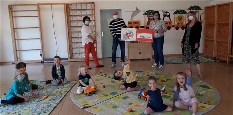 Die Kindertagesstätten-Leitung Frau Barbara Rech (links) sowie der Vorstand des Fördervereins freuen sich gemeinsam mit den Kindern über die neuen Spielteppiche. Foto: Förderverein Kindertagesstätte Spatzennest Sinzig e.V.