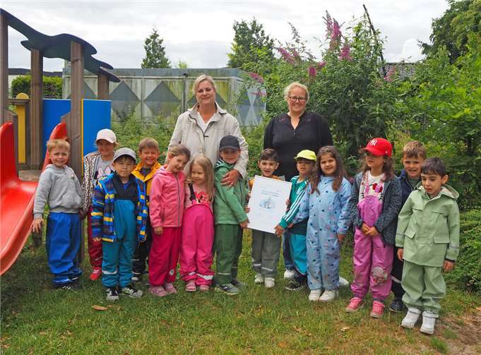 Die Kita-Kinder, hier mit der Fachkraft Christiane Heuer (hinten links) und der Kita-Leiterin Simone Kerz (hinten rechts), präsentieren stolz die Urkunde. Foto: Stadt Meckenheim