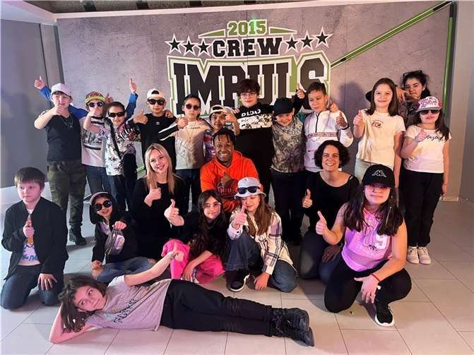 Die Klasse 4a der Geschwister Scholl Grundschule Neuwied: links Schulsozialarbeiterin Alexandra Hoffmann, mittig Tanzcoach Sam Yankey, rechts Klassenlehrerin Kerstin Knöll.