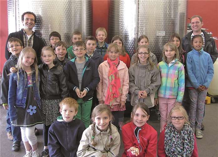 Die Klasse 4b der Grundschule am Blauen See mit Firmeninhaber Heinz Spitz (l.) und Grundschullehrer Marc Runkel (r.) im Fassraum.privat