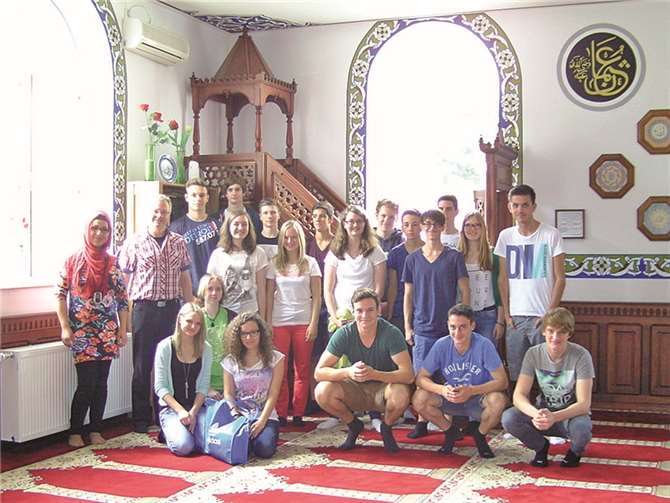 Die Klassen 10c/d (katholische Religion) mit Fatma Soenmez (1.v.l.) und Ralf Hoffmann (2.vl.) in der Mülhofener Moschee vor dem Minbar. Privat