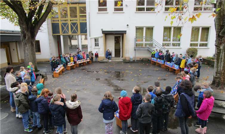 Die Klassen trafen sich mit ihren Lehrerinnen in einem großen Kreis auf dem Schulhof.