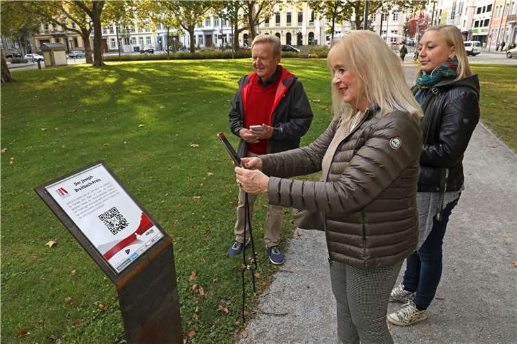 Die Koblenzer Kulturdezernentin Margit Theis-Scholz (Mitte) machte sich gemeinsam mit Inga Wüsthoff vom städtischen Kultur- und Schulverwaltungsamt (re.) sowie dem kulturpolitischen Sprecher der FDP-Stadtratsfraktion, Arnold Thieltges, ein Bild vom neu bestückten Literaturpfad am Clemensplatz. Ab sofort können sich Besucher hier über den Joseph-Breitbach-Preis sowie den diesjährigen Preisträger Karl-Heinz Ott per QR-Code informieren. Foto: Stadt Koblenz/Egenolf