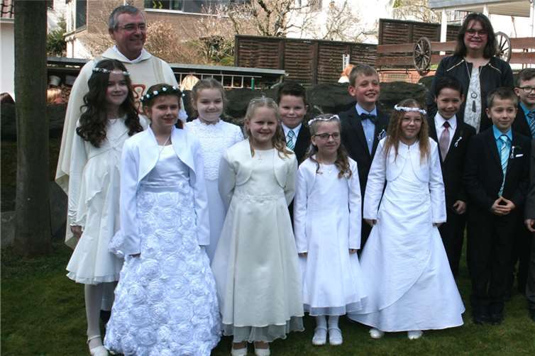 Die Kommunionkinder Jan-Luca Barz, Mika Eisenzapf, Lena Weber, Lisa Braun, Finja Maas, Nico Modrow, Maik Nett, Sarah Nett, Jonas Odenthal, Raphael Philippi, Katinka Schleich, Magdalena Szindler und Tobias Wilbertz freuten sich mit Pfarrer Marmann und Gemeindereferentin Christel Fassian-Müller nach der hl. Messe beim obligatorischen Erinnerungsfoto.-WER-