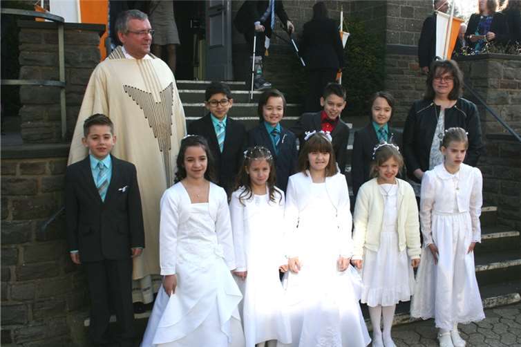 Die Kommunionkinder Kevin Peter Chan, Ty Markus Chan, Florian Diekmann, Elenor Mathieu, Noel Oesterling, Claudia Rizzo, Sarah Schubert, Aileen Vossemer, Ida Nikolay und Leon-Joel Thomas mit Pfarrer Günter Marmann und Gemeindereferentin Christel Fassian-Müller nach dem feierlichen Festgottesdienst in der Pfarrkirche St. Lambertus. WK