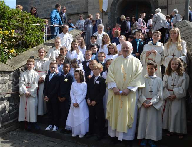 Die Kommunionkinder auf der Treppe der Kirche St. Philippus und Jakobus mit Pfarrer Erich Fuchs, Diakon Sebastian Pollitt und Barbara Brötz.