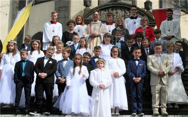 Leib Christi und das Jesuswort „Vertrau mir!“ standen im Mittelpunkt Die Kommunionkinder vor der Kirche mit Ministranten, Katechetinnen und Pfarrer Missong: (von links) Jannis Fell, Sabine Lohner, Nadine Laux, Pfarrer Norbert Missong, Bastian Fell, Evi Weinand, Leonard Schütz, Stephanie Schmitz und Raphael Weber. Foto: Birgit Busenkell