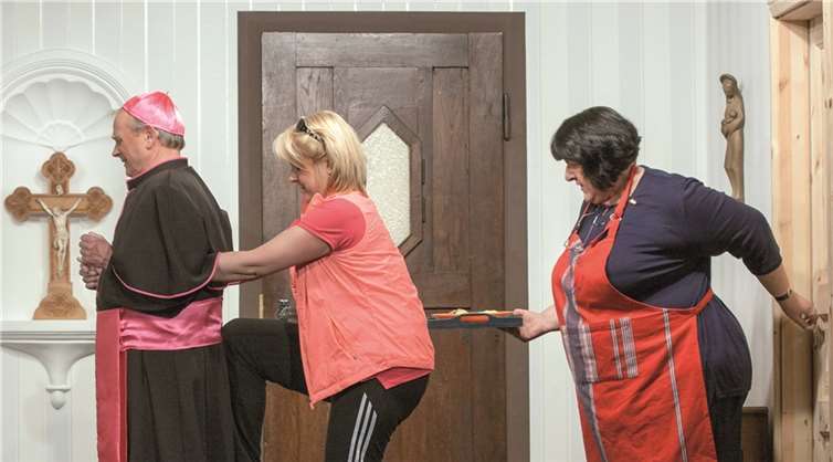 Die Kreuzschmerzen des Domkapitular behandelt Aerobiclehrerin Heidi ziemlich resolut, aber erfolgreich. Da kann Haushälterin Hermine (rechts) nur staunen.