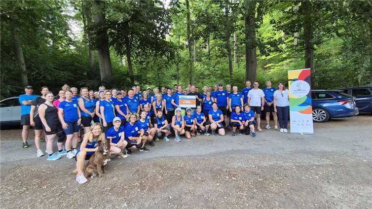 Die LSB-Inklusionslotsen Katja Froeschmann (Bildmitte) und Ronny Schöniger (3. v.r.) überreichten die INpuls-Prämie in Höhe von 500 Euro an das Orga-Team der LG Laacher See (in blauen Shirts von links nach rechts: Christine Bayer, Bernhard Schiffers, Roland Wesche, Raheb Rahimi und Markus Höbner). Foto: LG Laacher See