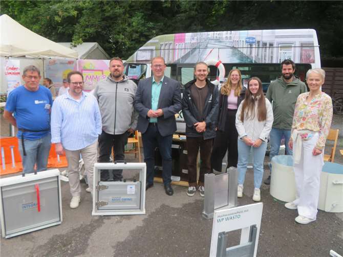 Die Landkreise Mayen-Koblenz, Neuwied und Westerwaldkreis, jeweils vertreten durch die Ersten Kreisbeigeordneten Pascal Badziong (2. v. l.), Philipp Rasbach (Mitte) und Gabriele Wieland (rechts) sowie Mitarbeiterinnen und Mitarbeiter der jeweiligen Unteren Wasserbehörde, hatten als Träger der Hochwasserpartnerschaft Wied-Saynbach, das Hochwasserinfomobil des HKC nach Bendorf eingeladen, worüber sich auch Stadtbürgermeister Christoph Mohr freute (3. v. l.).  Foto: Kreisverwaltung Westerwaldkreis / Roger Best