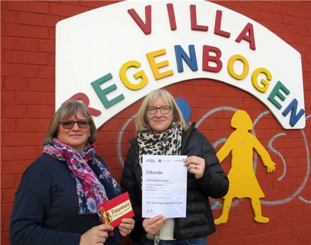 Die Leiterin der Kita Villa Regenbogen Alexandra Dietz (links) nimmt Urkunde und Gutschein von Nicola Haupt vom Rhein-Sieg-Kreis entgegen.