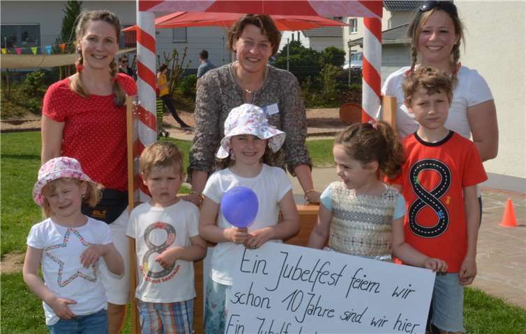 Die Leiterin des Familienzentrums „Drachenfelser Ländchen“ in Villip, Stefanie Weißenfels (Mitte), freut sich mit den beiden Erzieherinnen Larissa Heinz (rechts) und Anke Lohner (links) sowie einigen Kindern über die gelungene Jubiläumsfeier.JOST