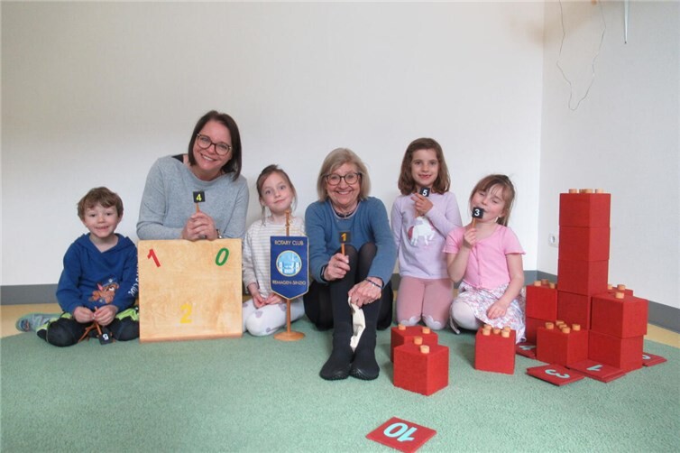 Die Leitung der Kita Pusteblume-Löwenzahn Frau Sandra Maxwell (l.) mit Frau Annegret Stegers, den Kindern der Kita und der rotarischen Mathekiste. 