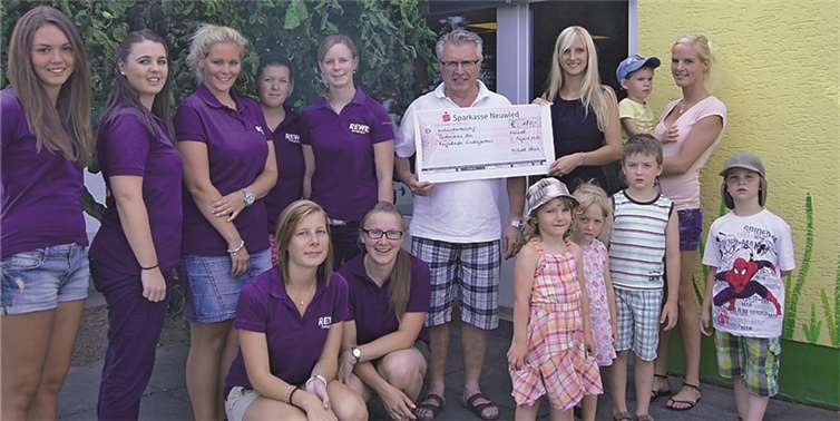 Die Maimädchen und Herr Glück übergeben den Scheck an den Förderverein des Kindergartens.privat
