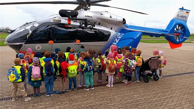Die Maxi-Kinder vor einem Polizeihubschrauber.