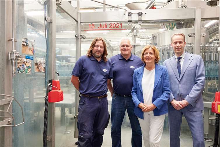 Ministerpräsidentin zu Besuch beim Sinziger Mineralbrunnen Die Ministerpräsidentin von Rheinland-Pfalz, Malu Dreyer, war am 08.06.2022 zu Gast beim Sinziger Mineralbrunnen und informierte sich vor Ort bei einem Betriebsrundgang über den Stand der Wiederaufbaumaßnahmen nach der Flutkatastrophe im Ahrtal. Im Hintergrund in Rot: Stand des Hochwassers in der Katastrophennacht. (V.l.n.r.: Andre Rick (stellv. Produktionsleiter), Jens Reinhold (Betriebsleiter), Malu Dreyer (Ministerpräsidentin RLP) sowie Thomas Beckmann (Geschäftsführer). Foto: Sinziger Mineralbrunnen GmbH