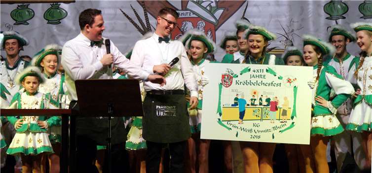 Die Moderatoren Peter Kirch und Oliver Koch präsentiertengleich zu Beginn den diesjährigen Sessions-Orden, der an dasnärrische Jubiläums des Kröbbelchesfestes erinnert (4x11 Jahre).