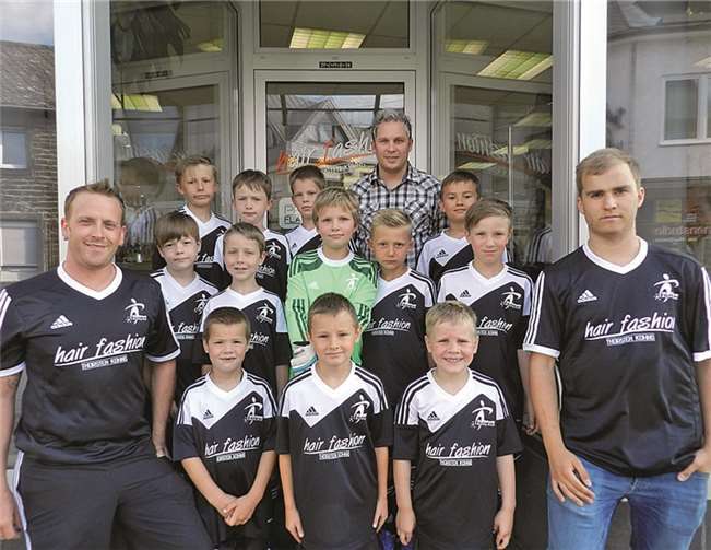 Die Nachwuchskicker präsentieren stolz ihre neuen Trikots, hier mit Sponsor Thorsten Kohns. privat