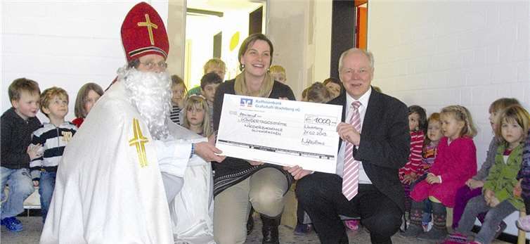 Die Niederbachemer Glühwürmchen, Kita-Leiterin Uta Jungfermann und Bürgermeister Theo Hüffel freuen sich sehr über die großzügige Geschenk vom Nikolaus. privat