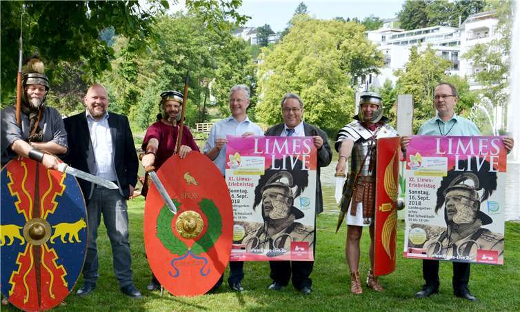 Die Organisatoren des elften Limes-Erlebnistags Limes Live stellten auf dem Landesgartenschaugelände das Programm vor. Der Pohler Ortsbürgermeister Prof. Thomas Steffen (2. v.l.), der Landrat des Rhein-Lahn-Kreises Frank Puchtler (4.v.L) und der Geschäftsführer der Wirtschaftsförderungs-Gesellschaft Rhein-Lahn Wolf-Dieter Matern (3.v.r.) hatten schon mal die Plakate und Werbeflyer für den Erlebnistag mit nach Bad Schwalbach gebracht. Darüber freute sich auch der Bad Schwalbacher Bürgermeister, Martin Hußmann (rechts). Für römisches Flair sorgten auch drei Auxiliar-Soldaten der mit dem Pohler Limeskastell befreundeten Kohorten aus der Nachbarregion. Ihre Schwerter zückten sie aber nur für die Kameras.Uwe Rindsfüßer