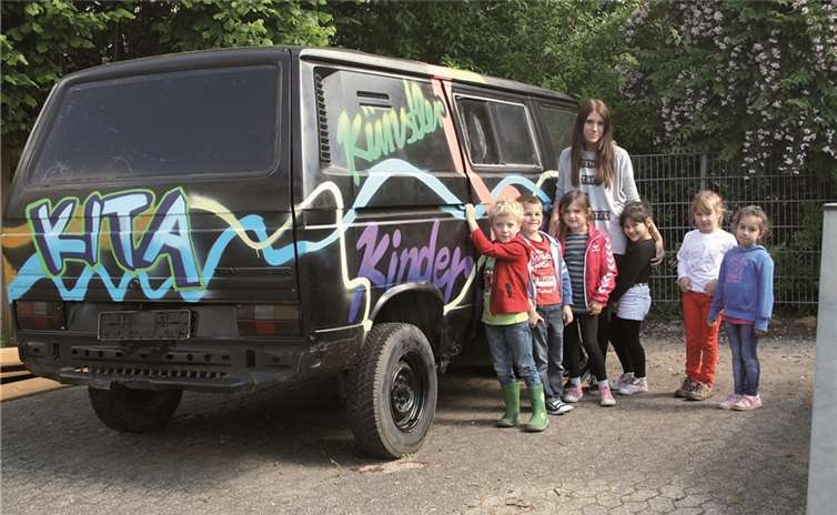 Die Projektkinder mit ihrem Bus, den sie selbst mit Graffitis besprüht haben. privat