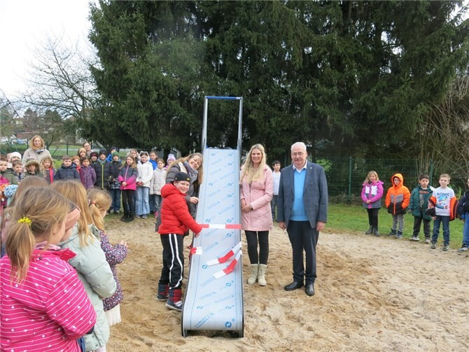 Die Rutsche wird eröffnet: Schüler Zacharias Preiß, Schulleitung Frau Doris Jörgler, Frau Sarah Preiß und Ortsbürgermeister Herr Willi Knopp