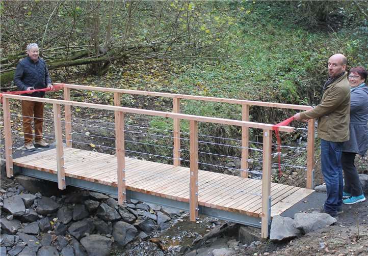 Die Schleifen zur Eröffnung wurden von Ortsbürgermeister Norbert Blath (1. von links ) auf Eitelborner Seite und Ortsbürgermeisterin Ute Kühchen und Gunnar Kuhlmann auf Kadenbacher Seite durchgeschnitten.