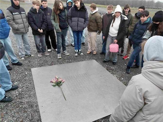 Die Schüler der 9. Klassen der Integrierten Gesamtschule an der auf Körpertemperatur erwärmten Gedenktafel für die Opfer des Konzentrationslagers Buchenwald.  Foto: Gudrun Grandrath