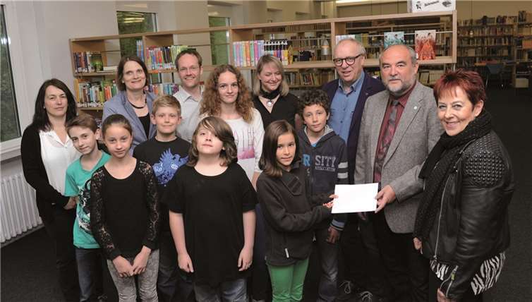 Die Schüler übergeben einen Scheck an den Vorstand des Kinderschutzbundes. -FIX-