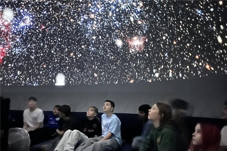 Die Schülerinnen und Schüler blicken fasziniert ins Universum.