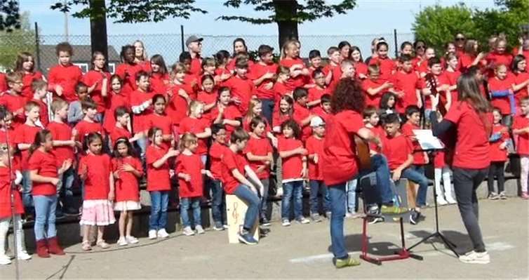 Die Schulgemeinschaft präsentierte ihren St. Peter Gesundheits-Song in ihren neuen roten Schul-T-Shirts. privat