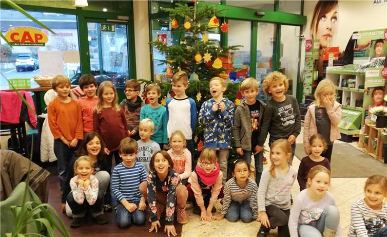 Die Schulkinder vor dem geschmückten Weihnachtsbaum.privat