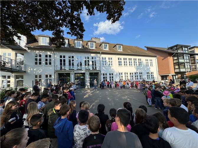 Die Schulleiterin Corinna Stühm begrüßt ihre KGS-Kinder bei Sonnenschein zum Maiansingen. Foto: privat