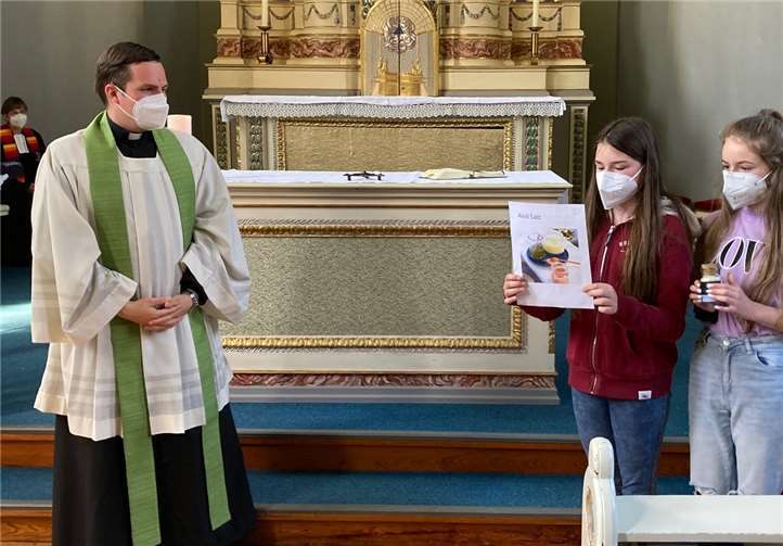 Die Sechstklässlerinnen Charlotte und Jolanta überreichen Pfarrer Daniel Sluminsky Aioloi-Salz – „als Zeichen des Zusammenhalts und Schutzes, und dass Sie immer vor Vampiren und anderen bösen Geistern geschützt sein werden“. Fotos: Erzbischöfliches St. Joseph-Gymnasium Rheinbach