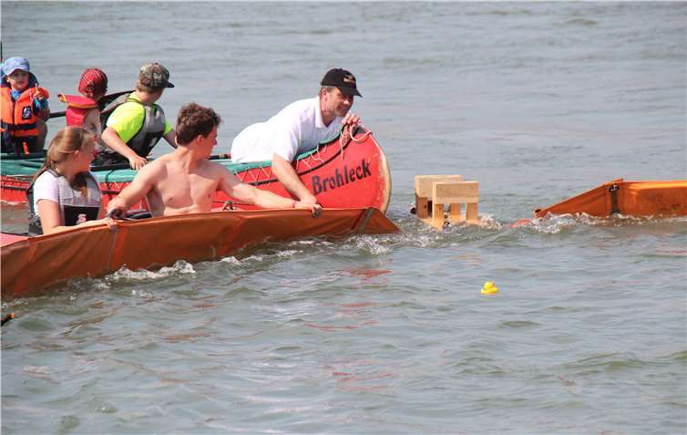 Die Sieger-Ente läuft im Ziel ein, woHelfer der Wassersport-Abteilung und der Feuerwehr warten.