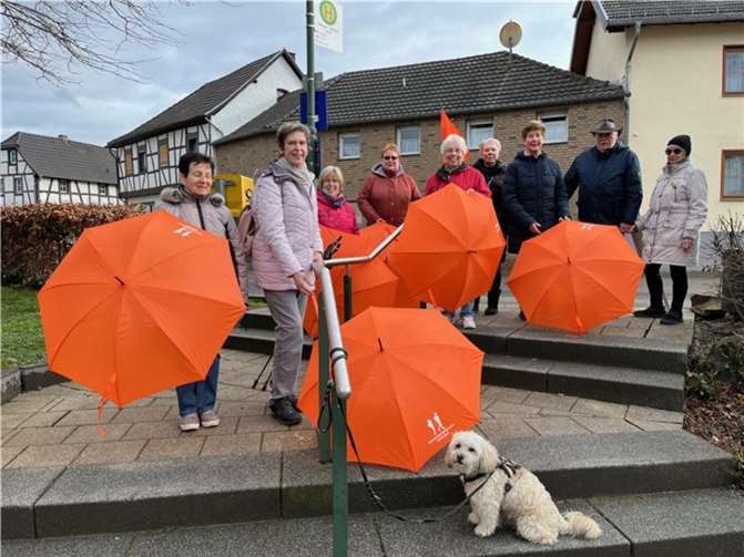 Die Spaziergangsgruppe am Treppeneingang zur Ortsmitte. Mit dabei, die von der Raiffeisenbank Voreifel eG gestifteten Regenschirme, mit dem passenden Emblem „Spaziergangsgruppe Oedingen“.  Foto: Olaf Wulf