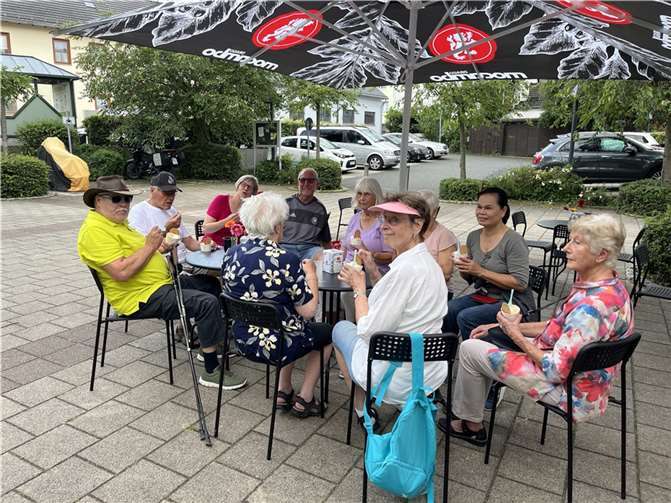 Die Spaziergangsgruppe auf dem Ortsmitteplatz vor der Eisdiele  Foto: Reiner Glasmacher
