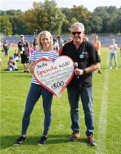 Die Special Olympics-Familie hält zusammen und unterstützt die Caritas Werkstatt in Sinzig: Dietmar Thubeauville, geschäftsführender Vizepräsident von Special Olympics Rheinland-Pfalz e.V. überreicht Carmen Glöckner den Förderscheck mit der Fördersumme, den die Sportler:innen mit ihrer Teilnahme generierten.Quellen: Special Olympics Rheinland-Pfalz e.V.