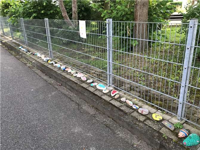 Die Steinschlange schlängelt sich am Zaun des Siedlungsspielplatzes entlang.