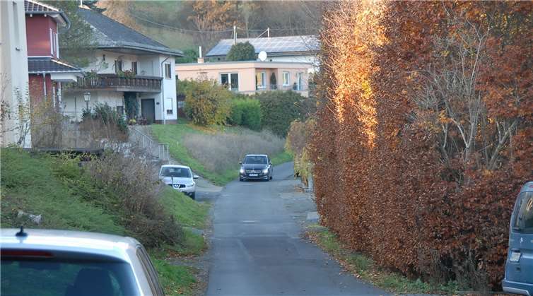 Die Straße ist jetzt sehr schmal und soll auf sechs Meter Breite ausgebaut werden, damit Autos auch im Begegnungsverkehr aneinander vorbei kommen.