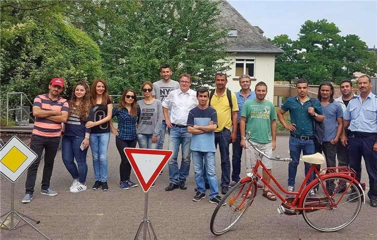 Die Teilnehmer der Flüchtlingsmaßnahme „Leben-Qualifizieren-Arbeiten“ mit Polizeioberkommissar Norbert Baulig (rechts im Bild) bei ihrem Verkehrstraining auf dem Schulhof der Andernacher Martinschule. prviat