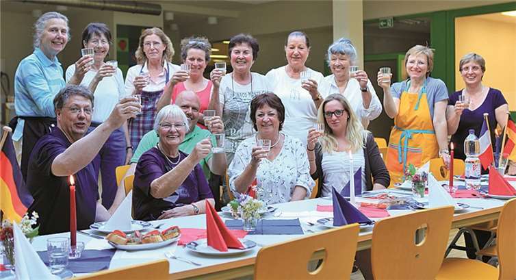 Die Teilnehmerinnen und Teilnehmer des französischen Kochabends freuen sich nach getaner Arbeit auf das leckere Menü. privat