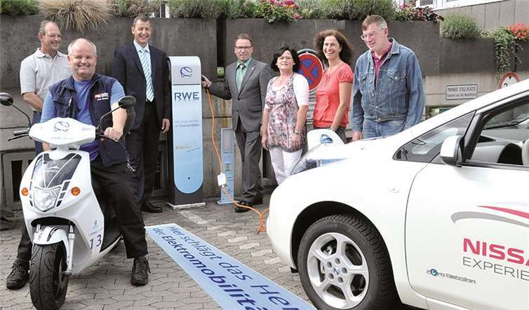 Die Testfahrten-Gewinner mit Oberbürgermeister Wolfgang Treis, RWE-Repräsentant Michael Dötsch und den Fahrzeugen an der Stromtankstelle. BS