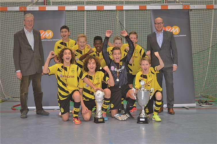 Die U13 von Borussia Dortmund erhielt den Sieger- und den Wanderpokal des evm Junior-Cups 2014 aus den Händen von evm-Unternehmenssprecher Christian Schröder (rechts im Bild) und Albert Weiler, dem 1. Beigeordneten der Stadt Mülheim-Kärlich (links im Bild). privat