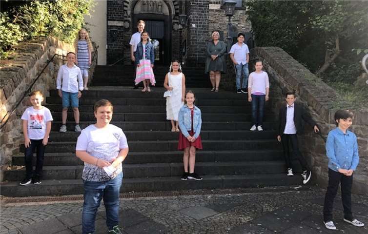 Die Viertklässler der 4 b vor der Pfarrkirche Sankt Arnulf mit ihrer Klassenlehrerin Martina Wilbert und ihrem Pfarrer Norbert Missong. Foto: Tatjana Boos